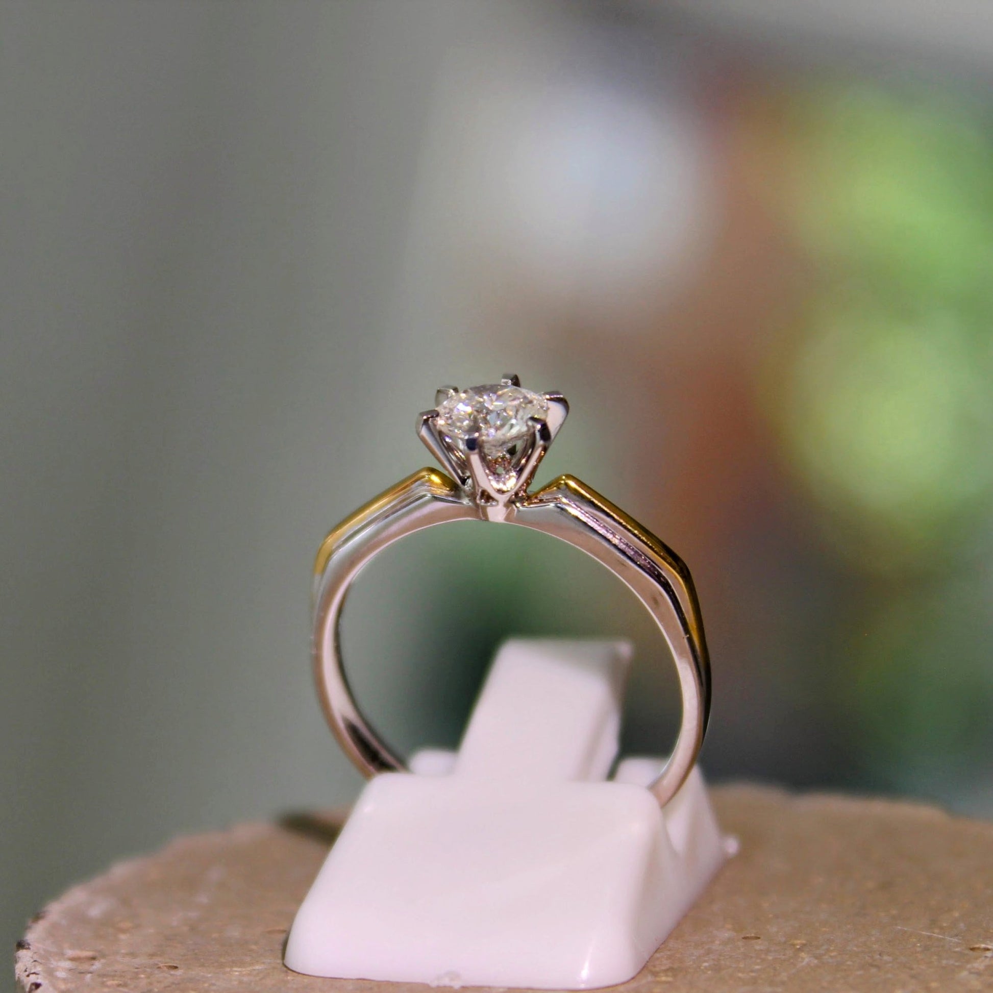Close-up of a two-tone diamond engagement ring featuring a brilliant solitaire diamond set in 18K solid gold. The ring showcases the fine craftsmanship and modern design, perfect for engagements or special occasions.