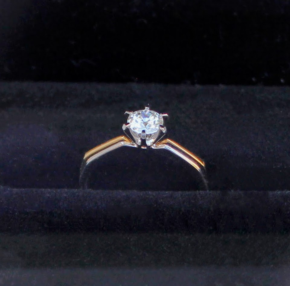 A two-tone diamond engagement ring displayed in a black jewelry box, featuring a solitaire lab-grown diamond set in 18K solid gold. The ring’s timeless design is ideal for engagements or special occasions.