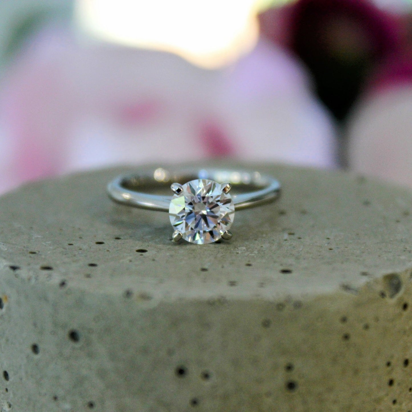 Close-up of a four-prong solitaire engagement ring featuring a brilliant lab-grown diamond set in a sleek 18K white gold band.